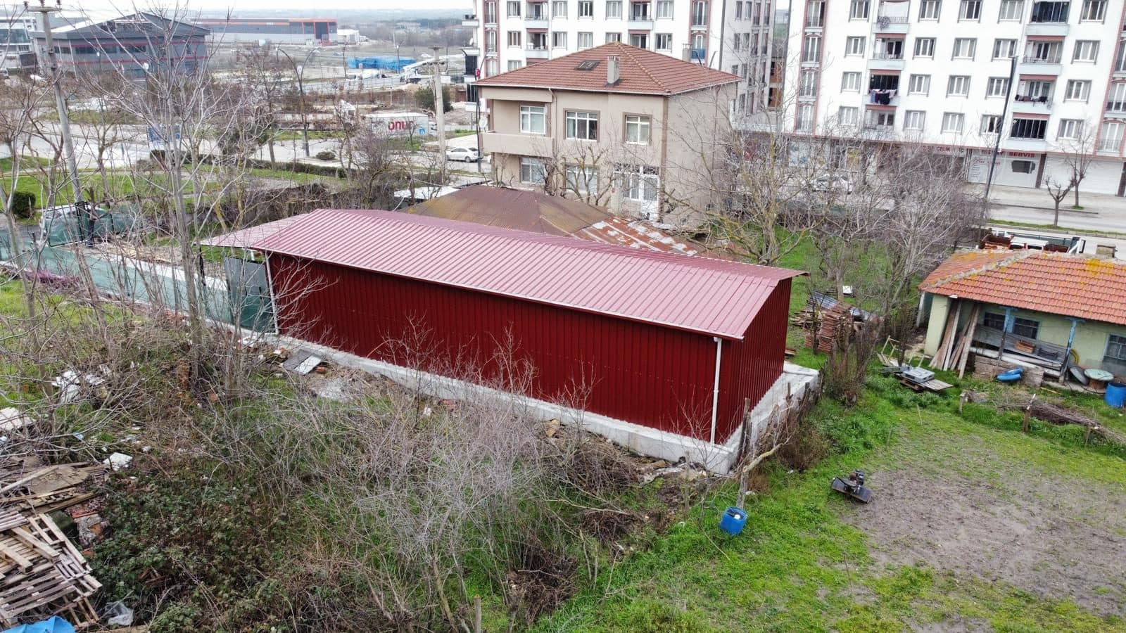 Bordo trapez sac ile kaplanmış çelik depo yapısı, havadan görünüm